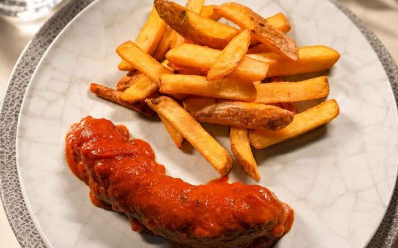 Mittagsgericht im Restaurant Neander Currywurst Pommes